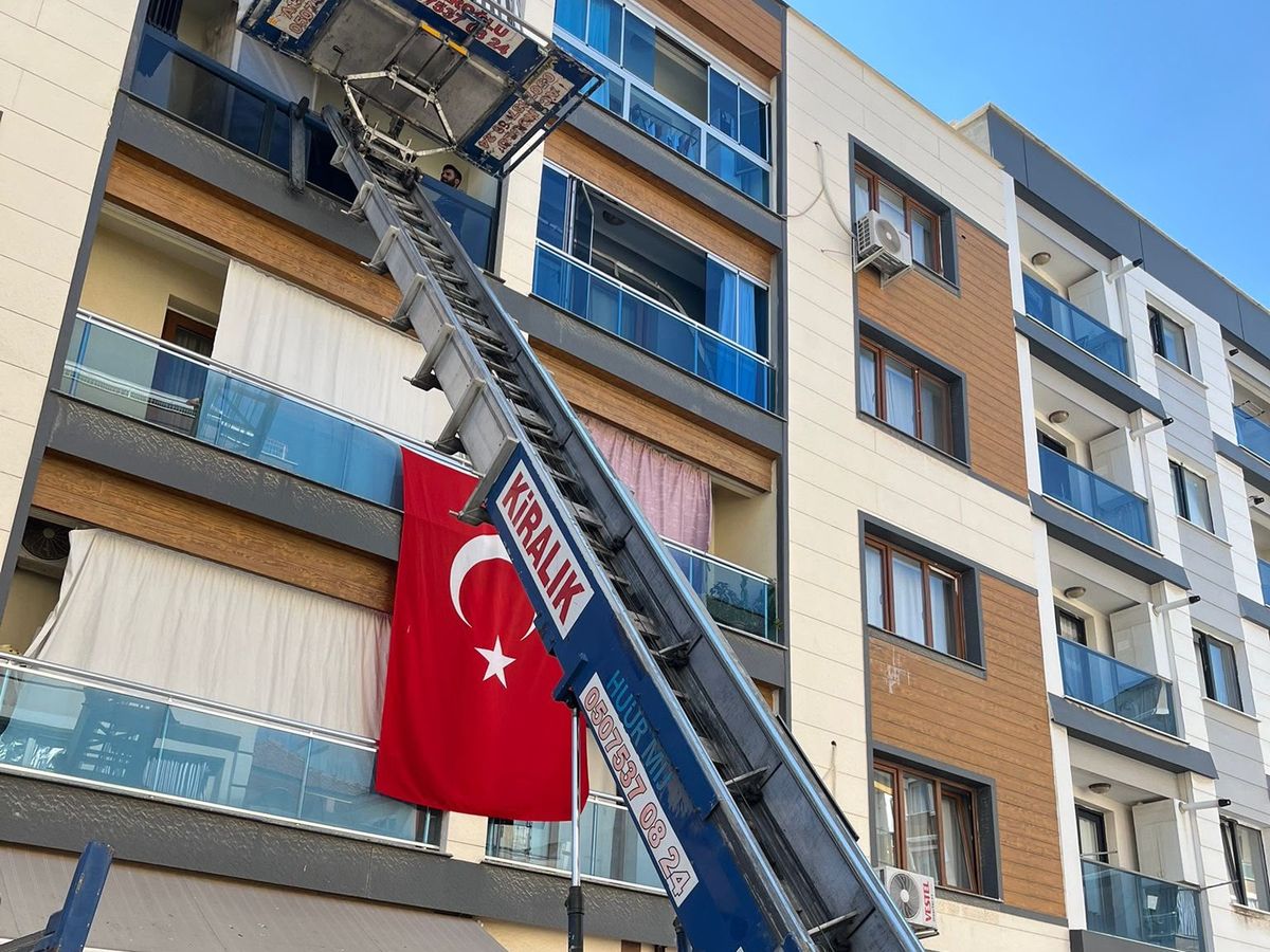 Kurulu haldeki mobil asansör: platformu balkon hizasında, rayları binaya dayalı